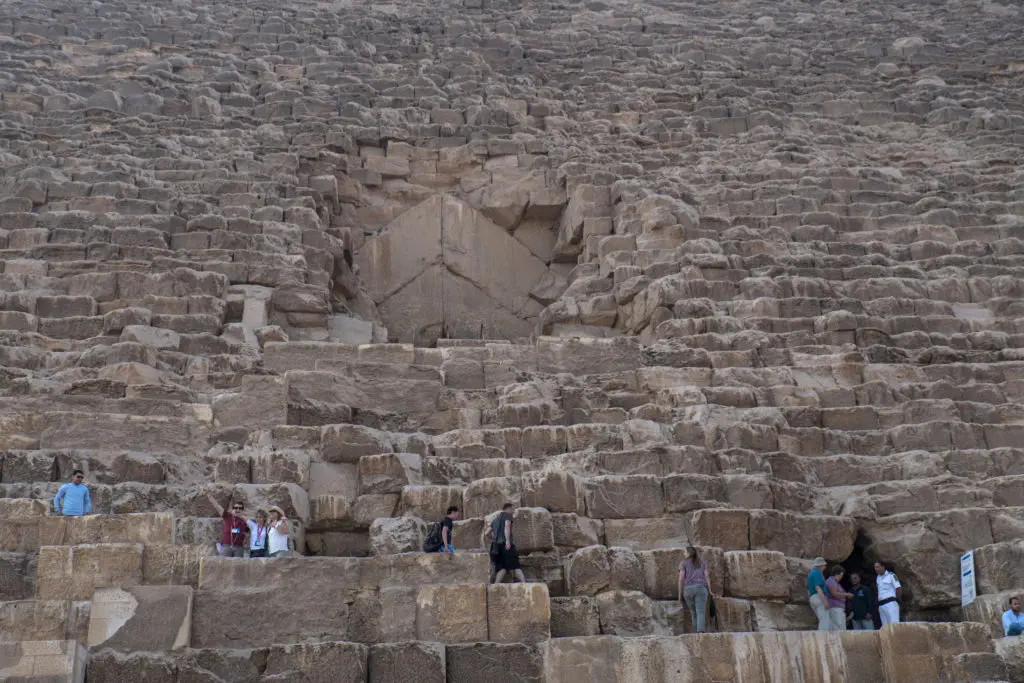 Climbing few levels of the Great Giza Pyramid to reach the gate is allowed