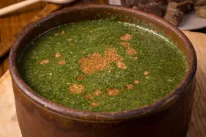 Egyptian Molokhya, Mulukhiyah, or Molokhia is finished at serving table in some restaurants